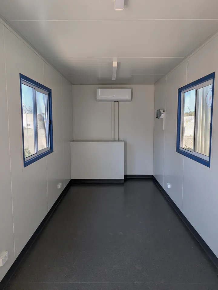 Interior of a modified container office, lined and insulated with windows and air conditioning